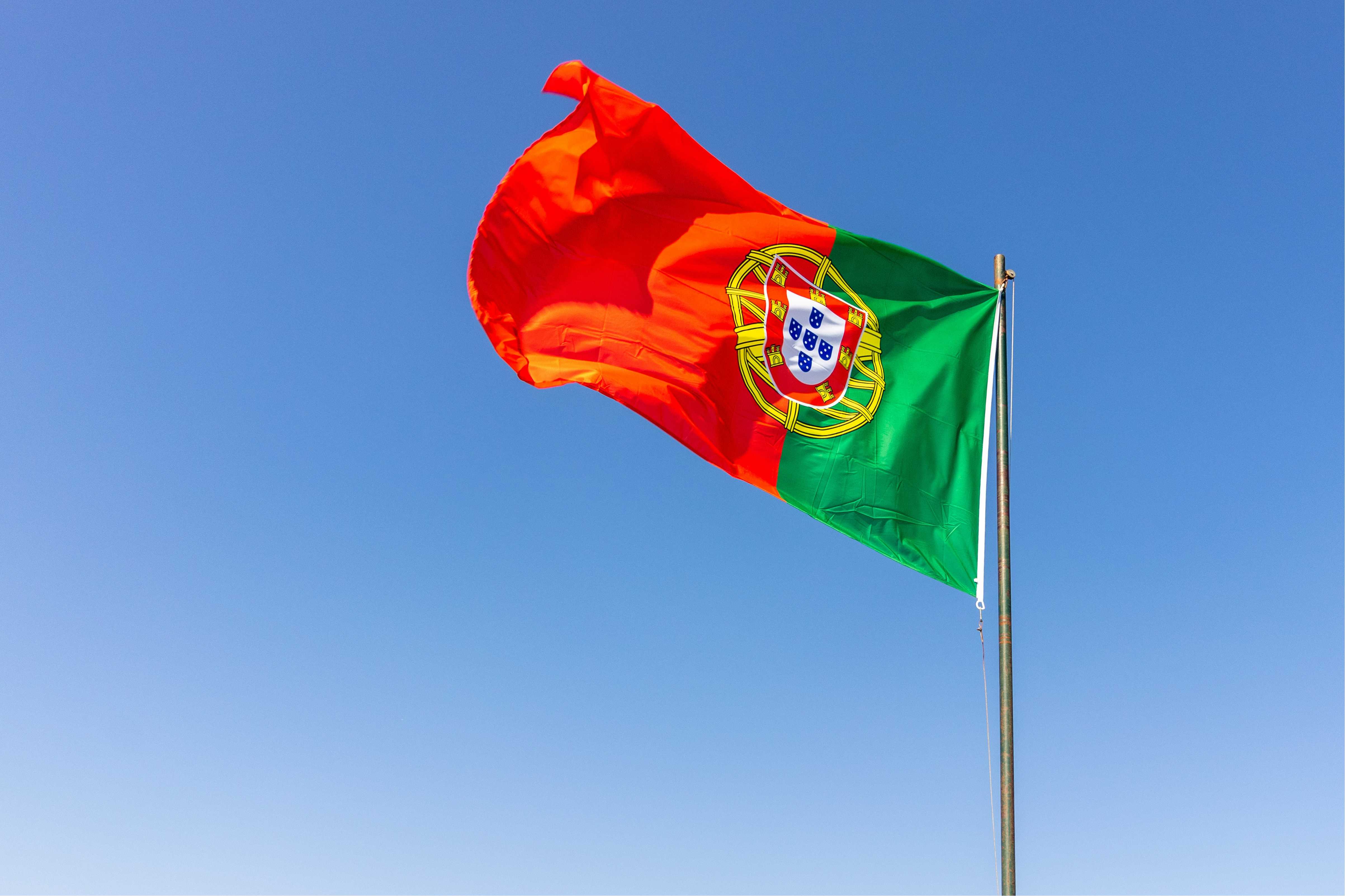 Bandeira de Portugal com o céu azul ao fundo