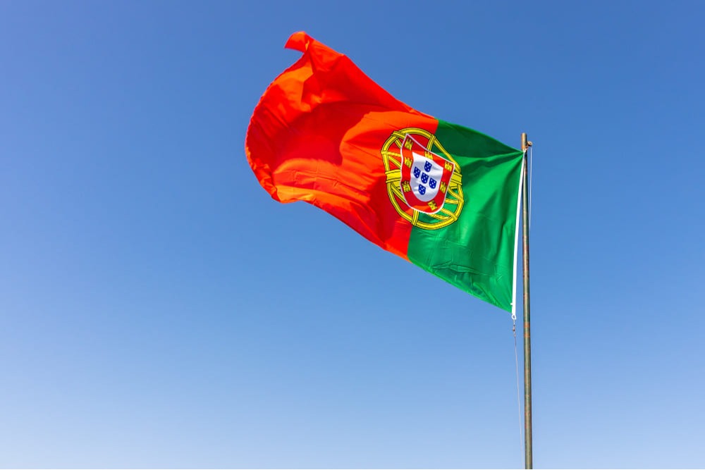 Bandeira de Portugal com céu azul ao fundo